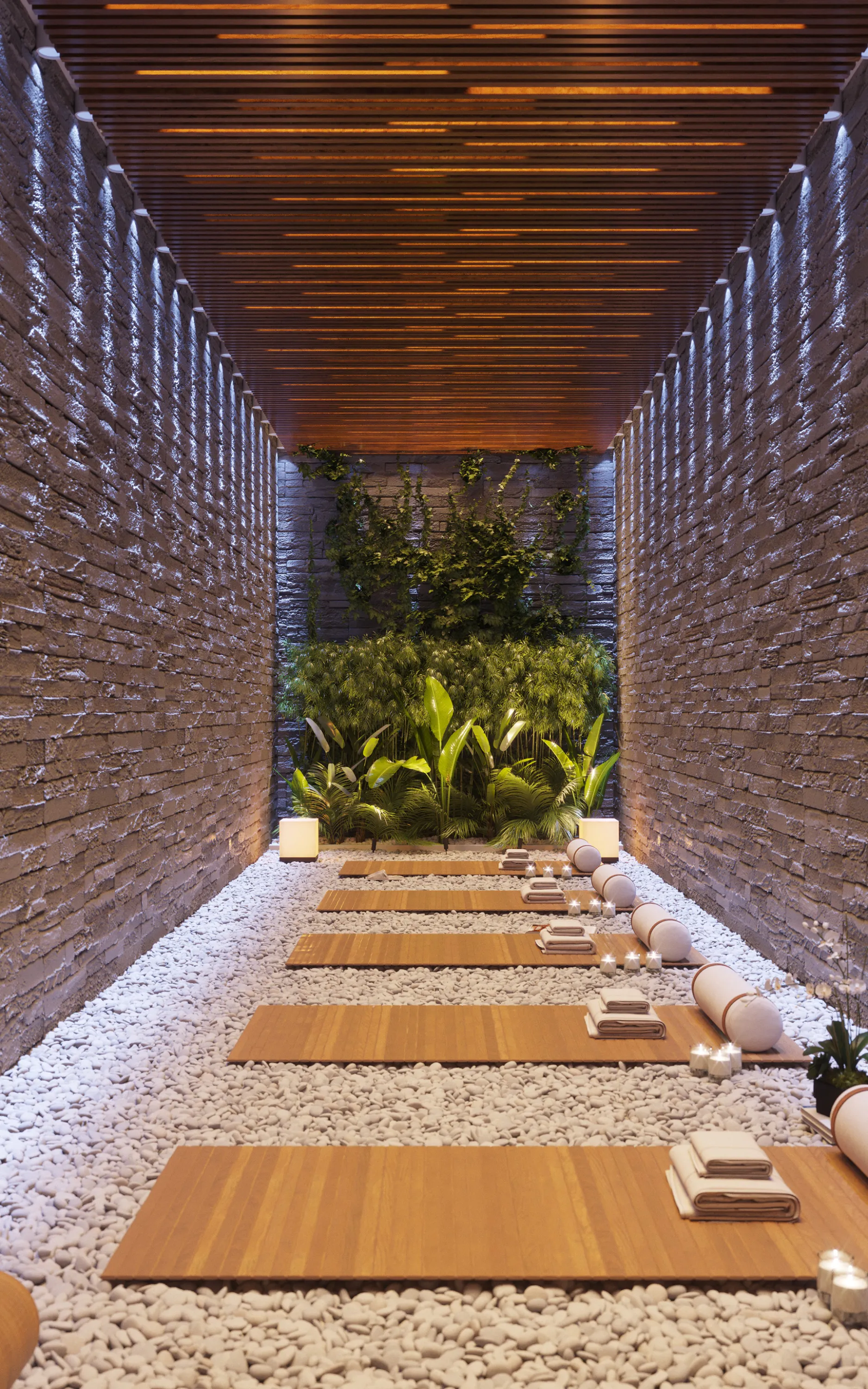 Meditation room with a green wall feature, stone walls and little pebbles on the ground.