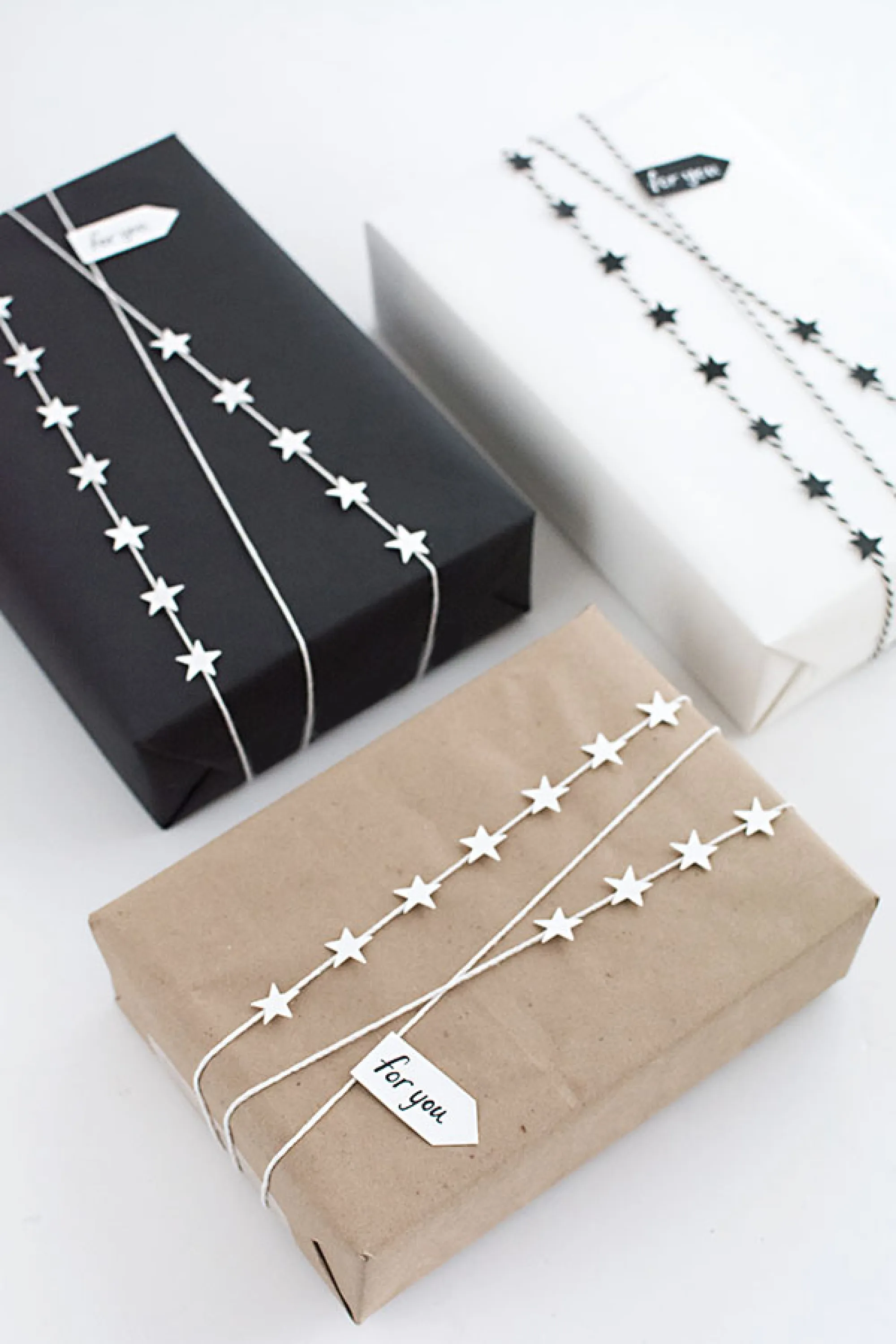 White and black and brown paper decorated with a garland made of twig and small cut-out stars.