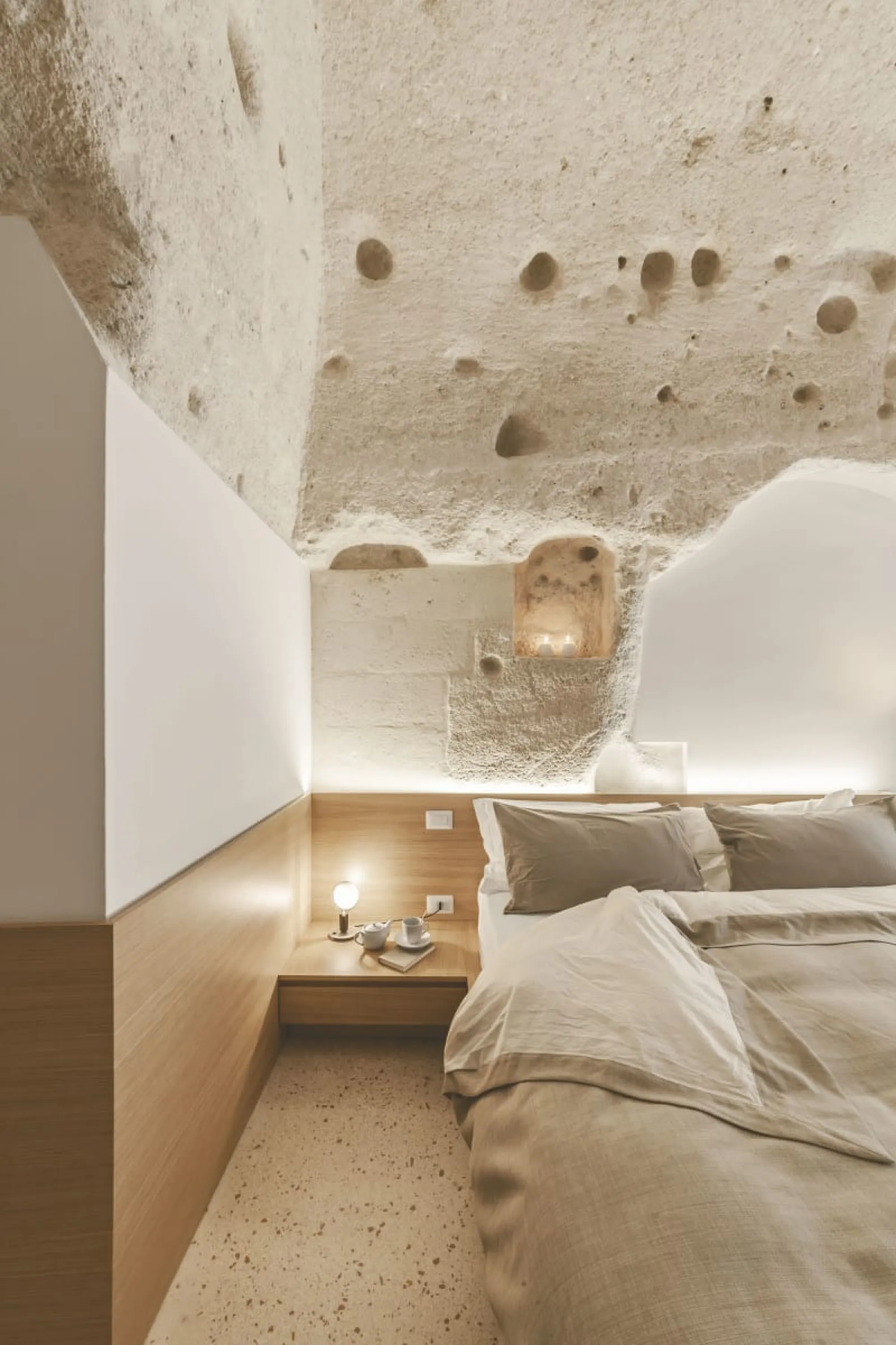 Contemporary bedroom design built in a traditional building with raw stone walls.