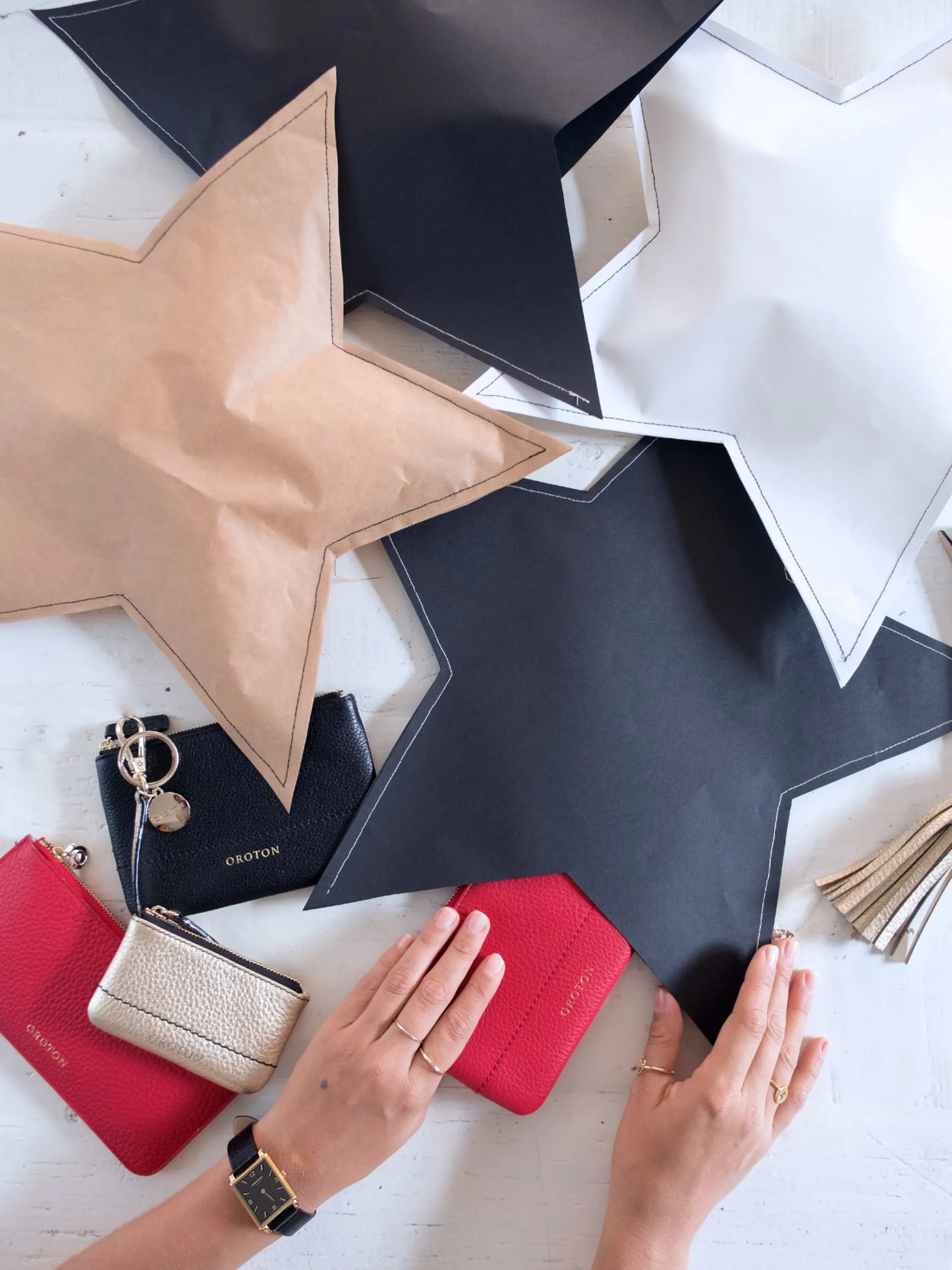 White, black and brown paper cut in the shape of a star a stitched to make a creative gift wrapping.