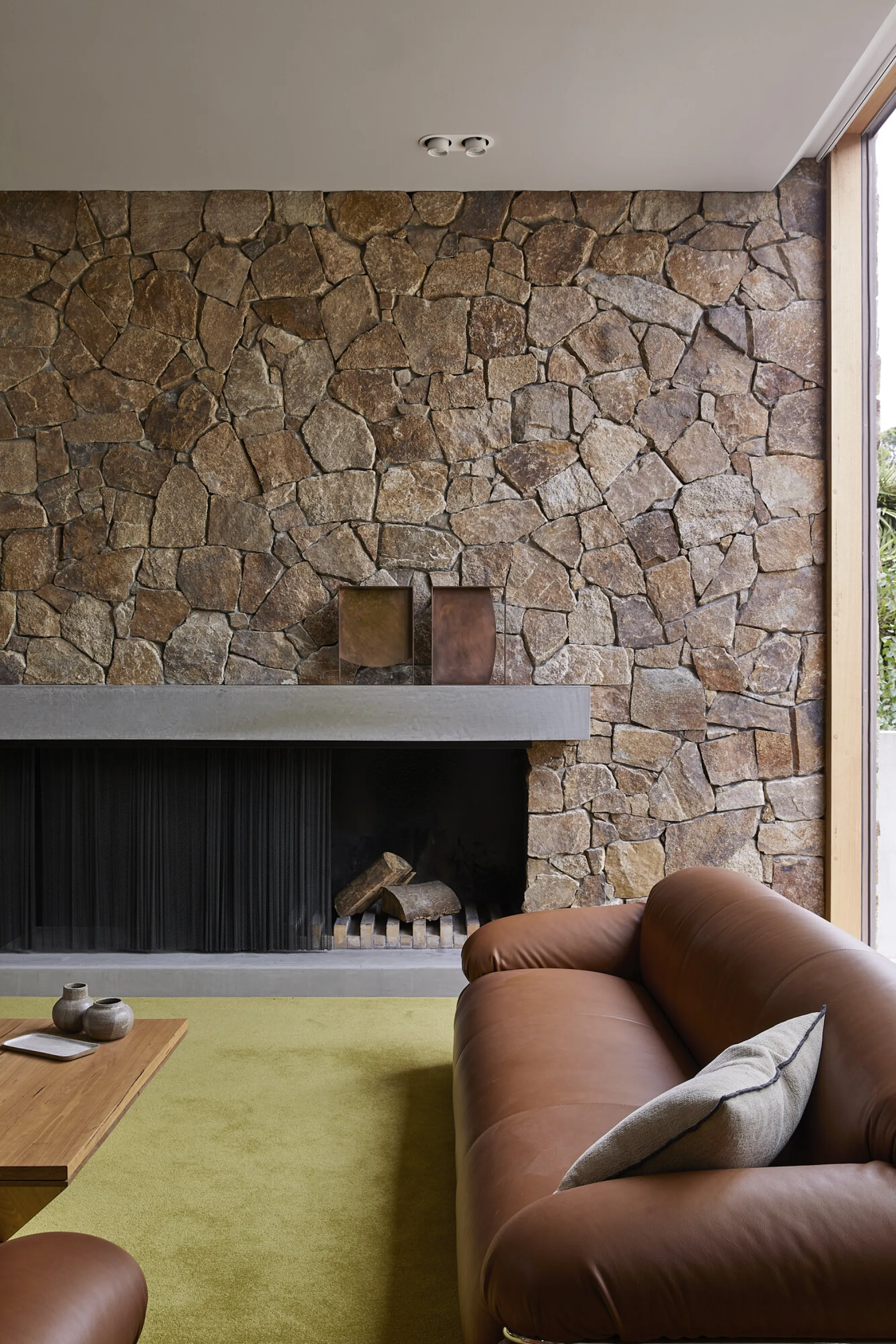 Stone wall on the back wall of a living room.