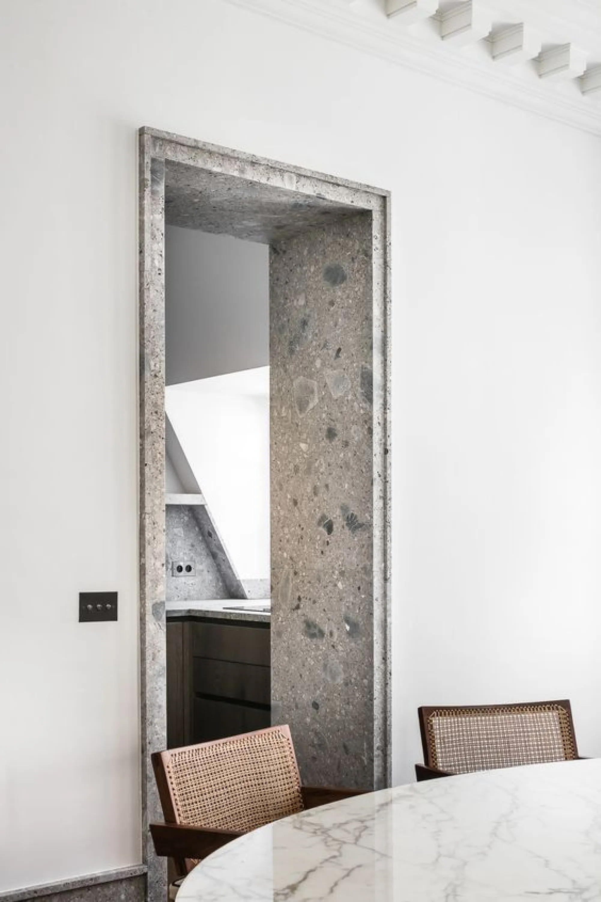 Marble doorway contrasting with a white smooth wall.