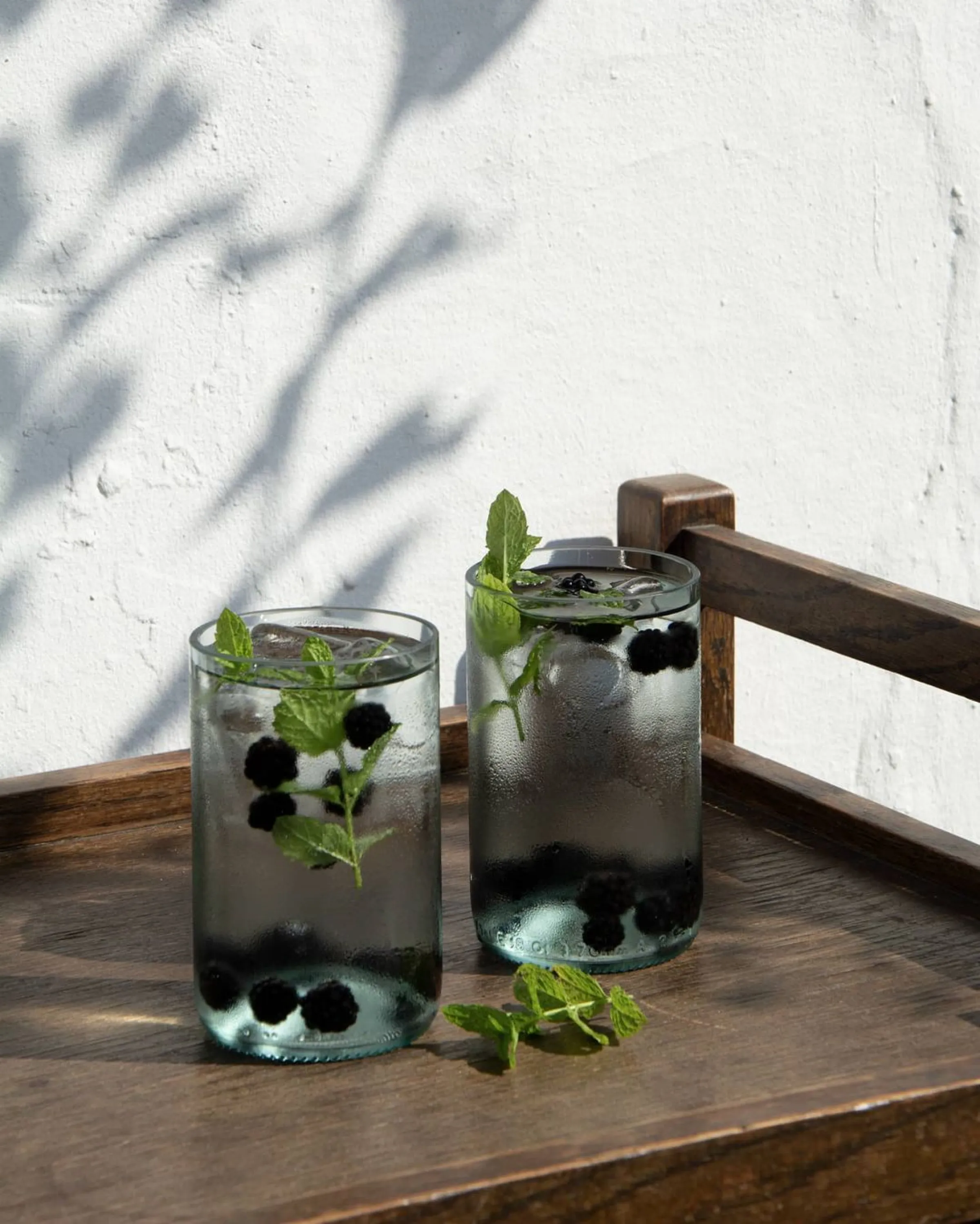 Recycled glass water glasses styled on a bar cart.