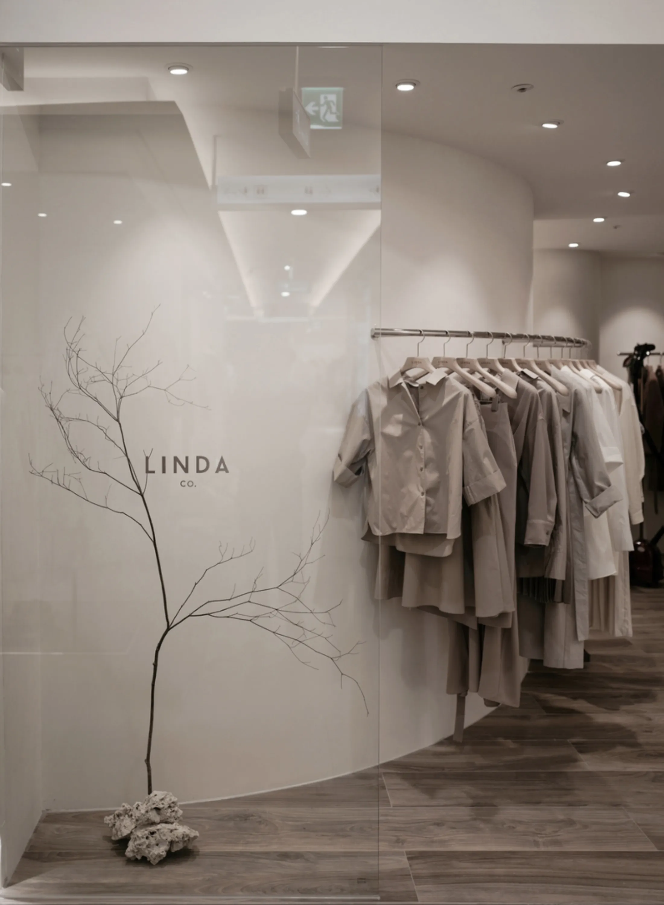 Shop with glass wall and a branch behind.