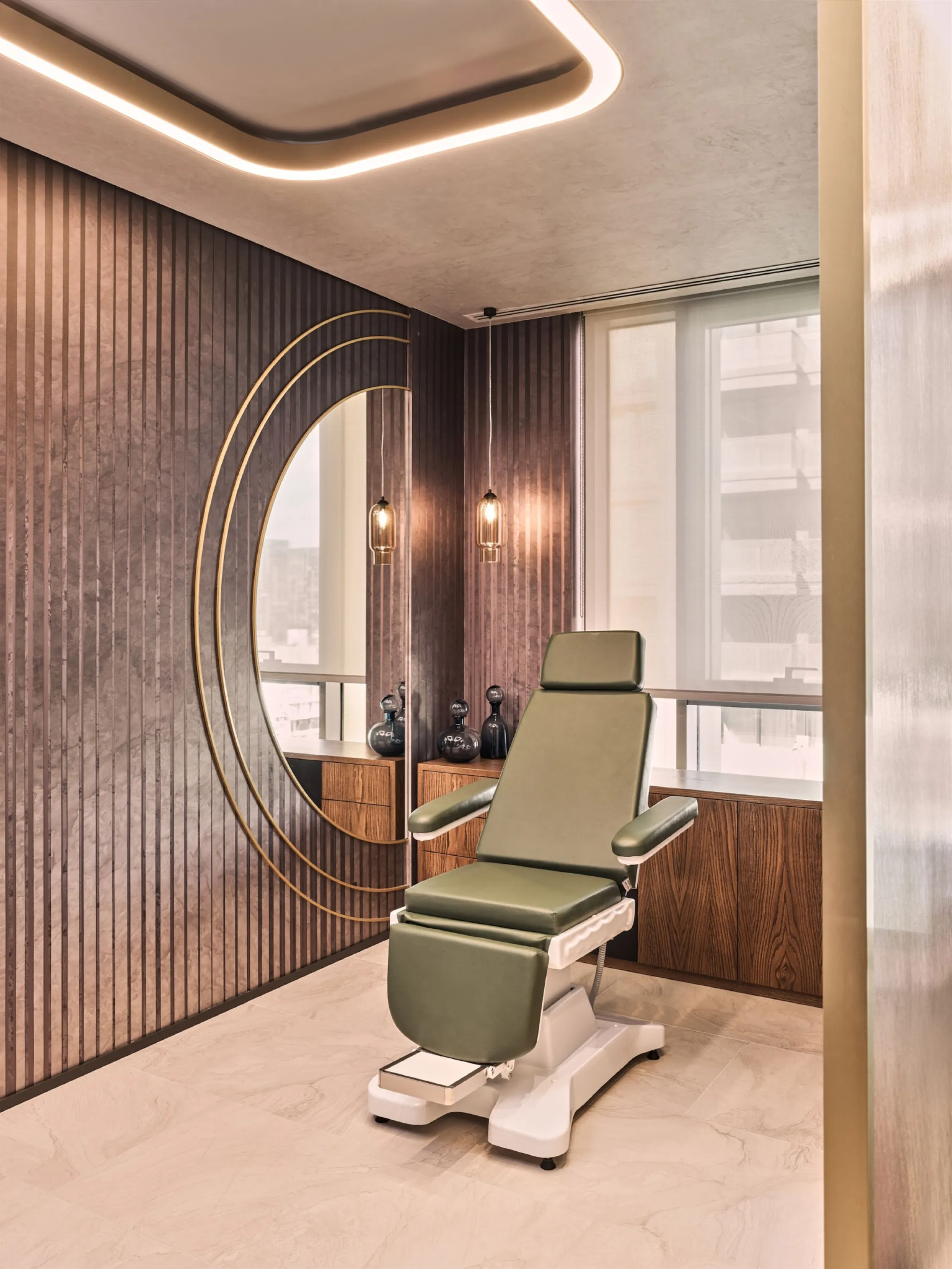 Treatment room with a wood panelled wall and interesting ceiling light.