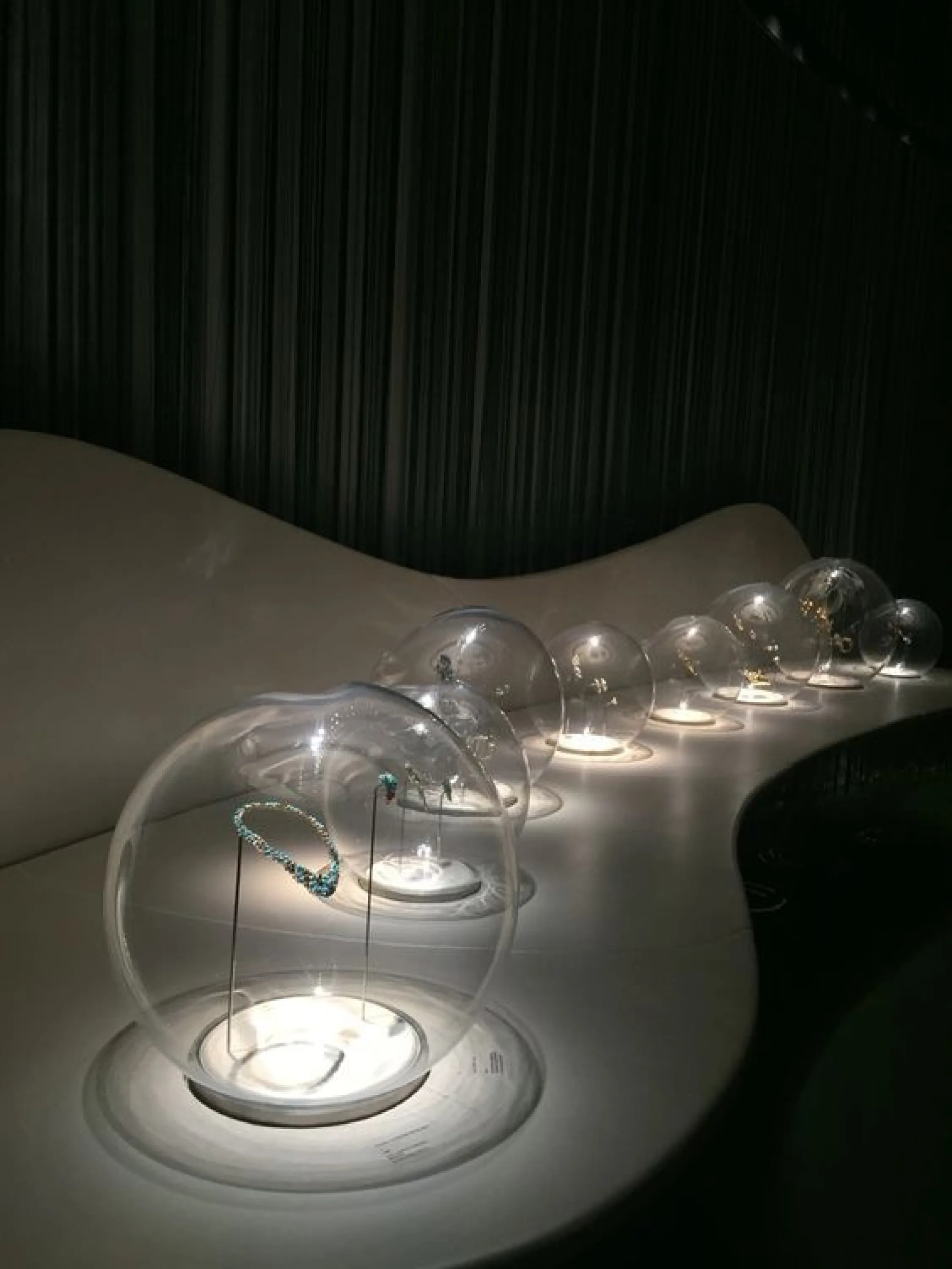 Dark store with jewels exposed into baubles being the only lit elements in the space.