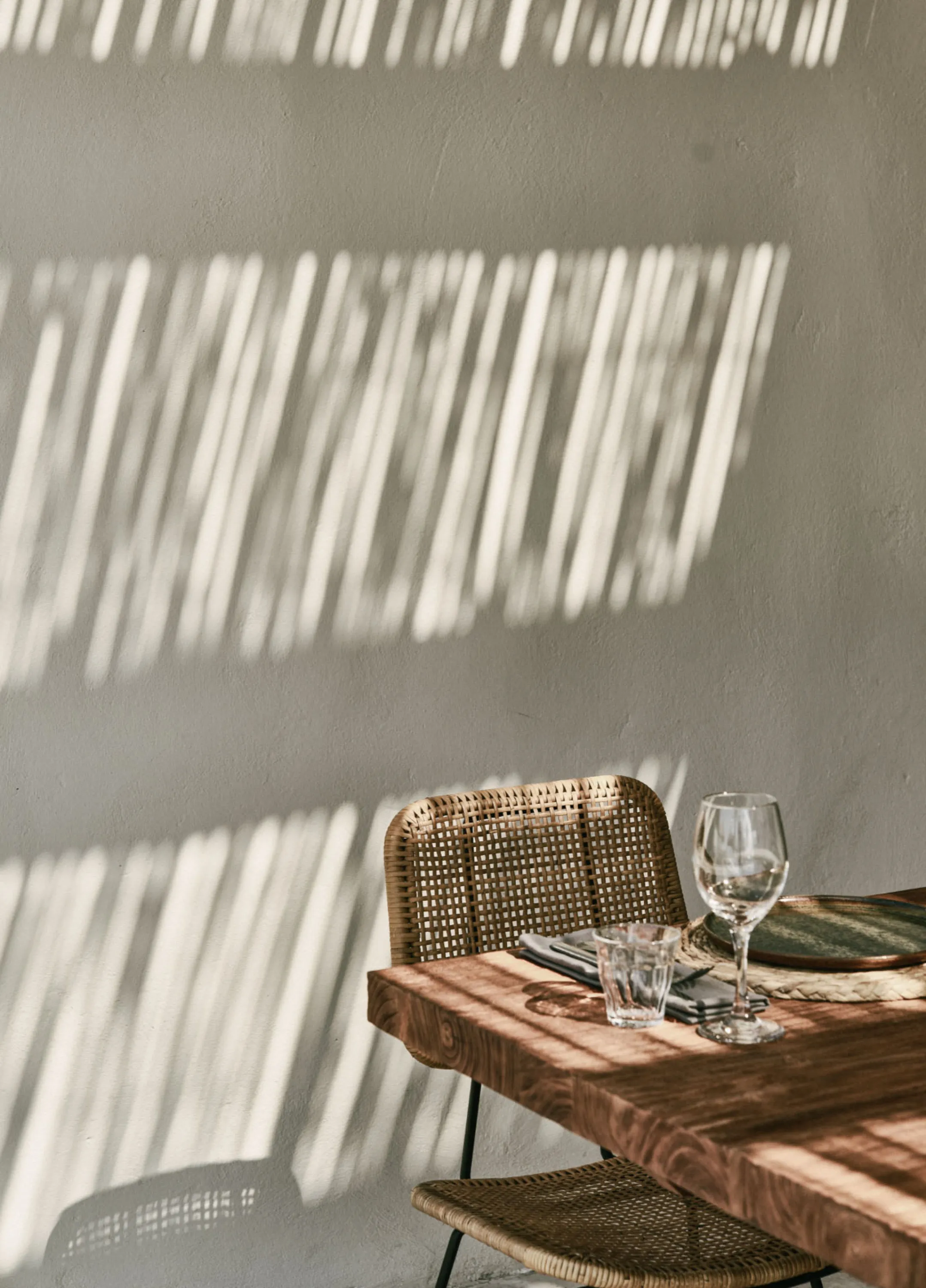 Light casting shadows on a wall in an outdoor patio.