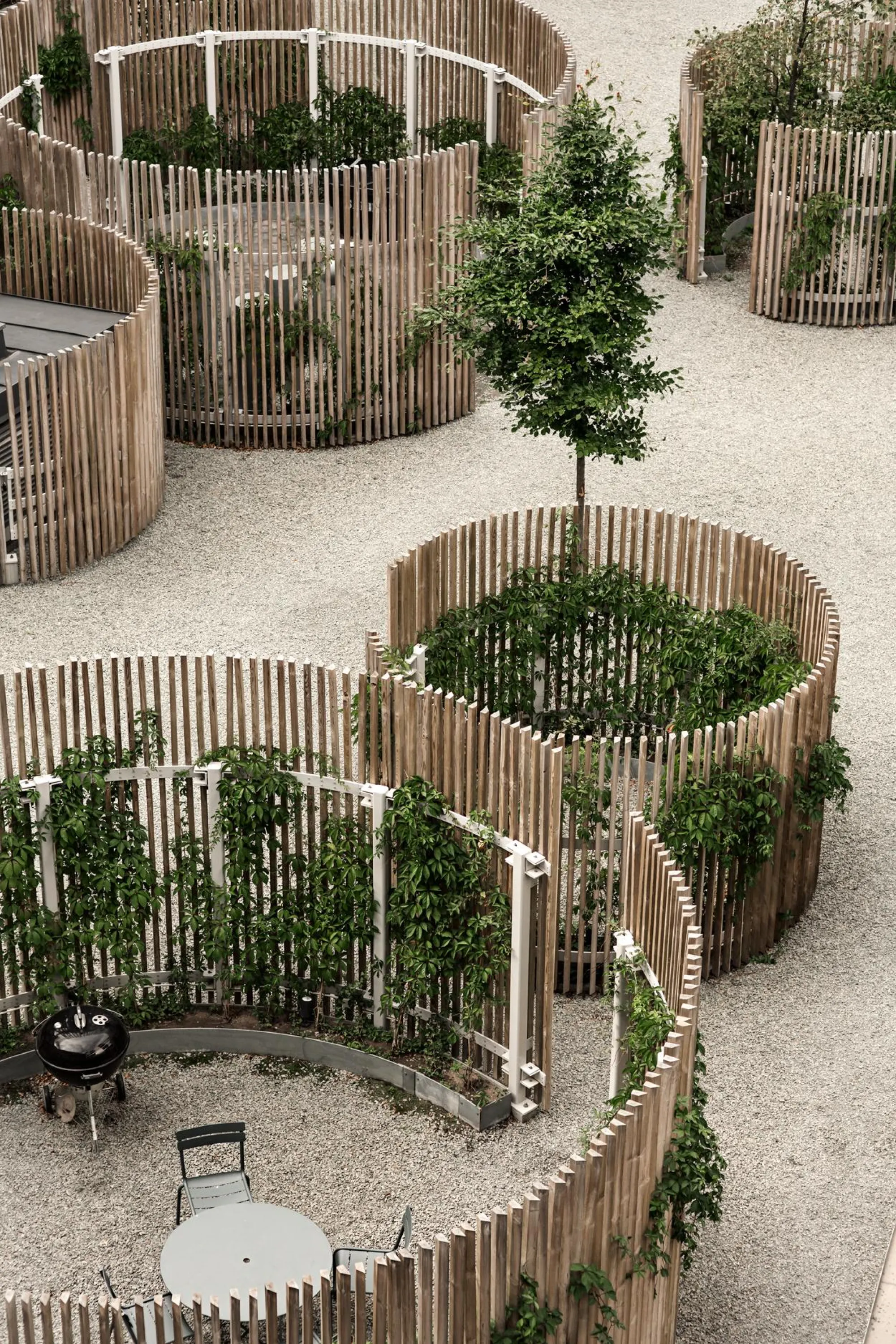 Public space partitioned in "outdoor rooms" with wooden poles.