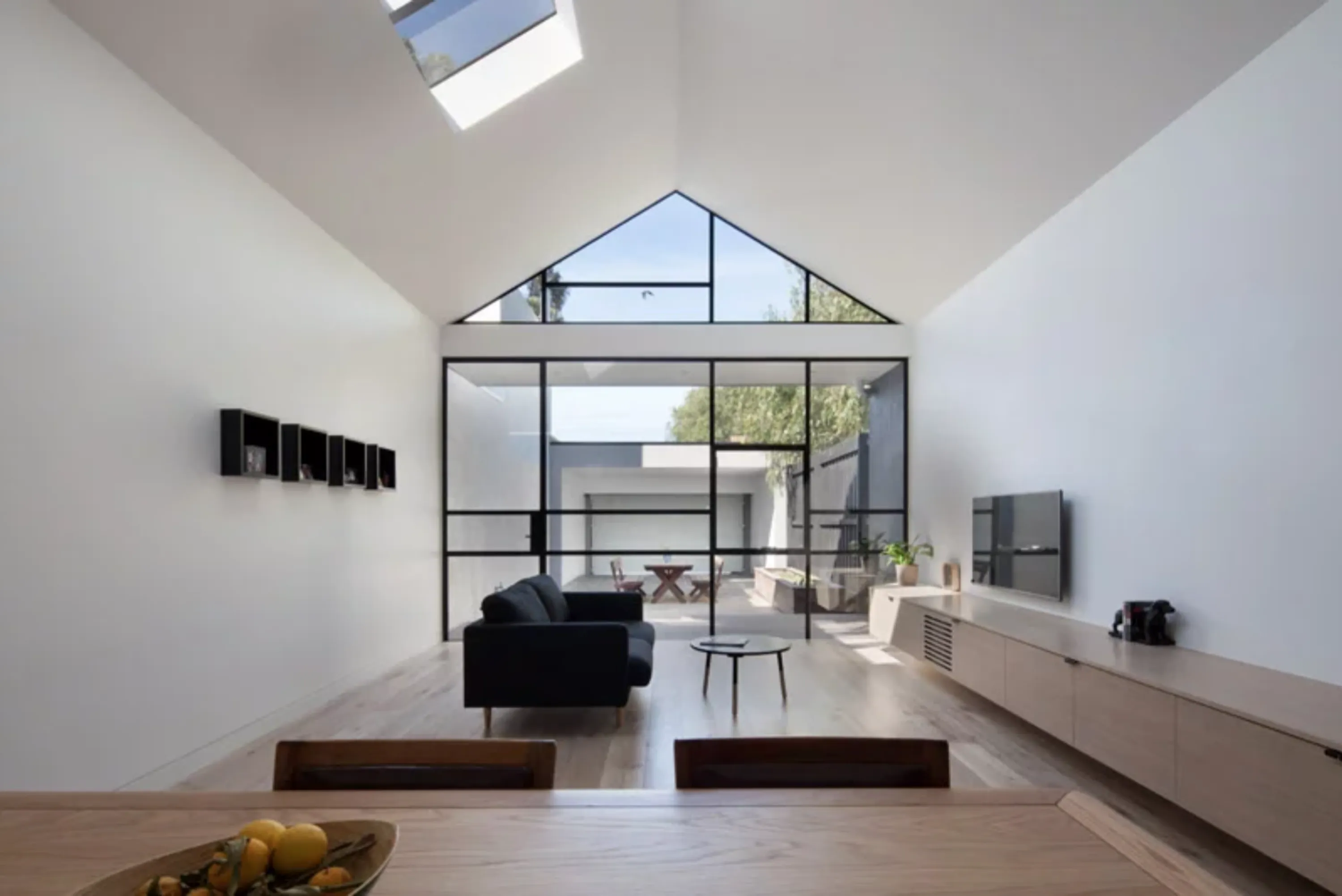Open plan minimal apartment, with uninterrupted view from the kitchen to the patio, great example of biophilic design.