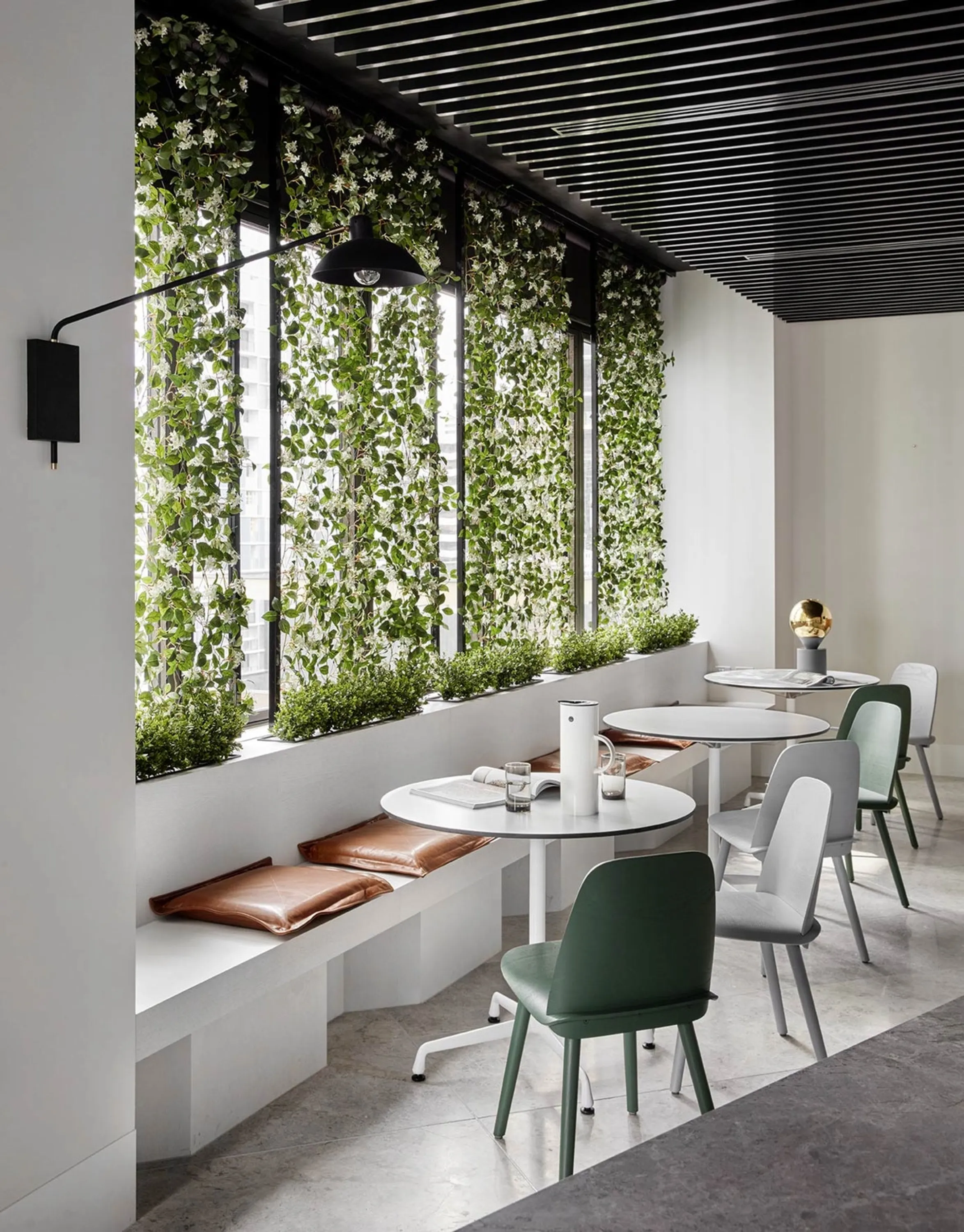 Garden wall design feature in a minimalist dining area, great example of biophilic design.