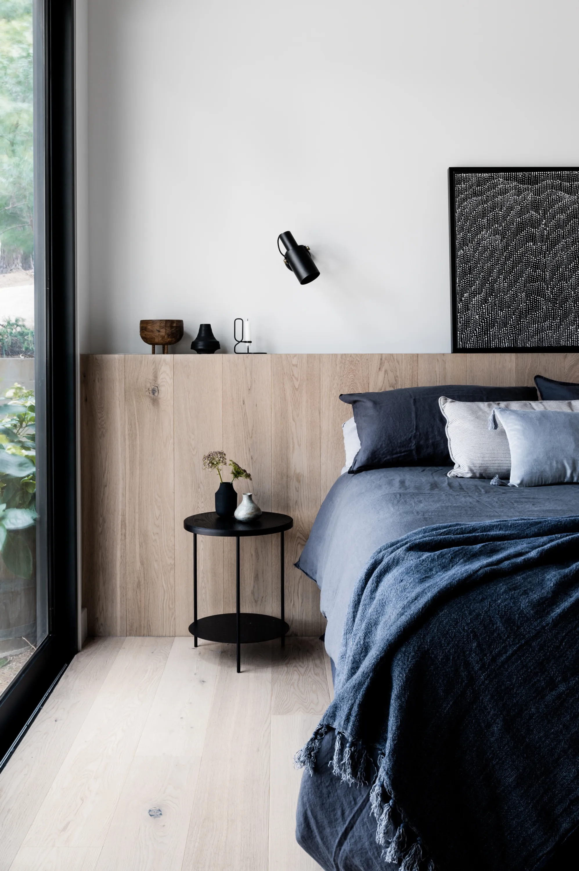 Minimalist bedroom with big window, great example of biophilic design.