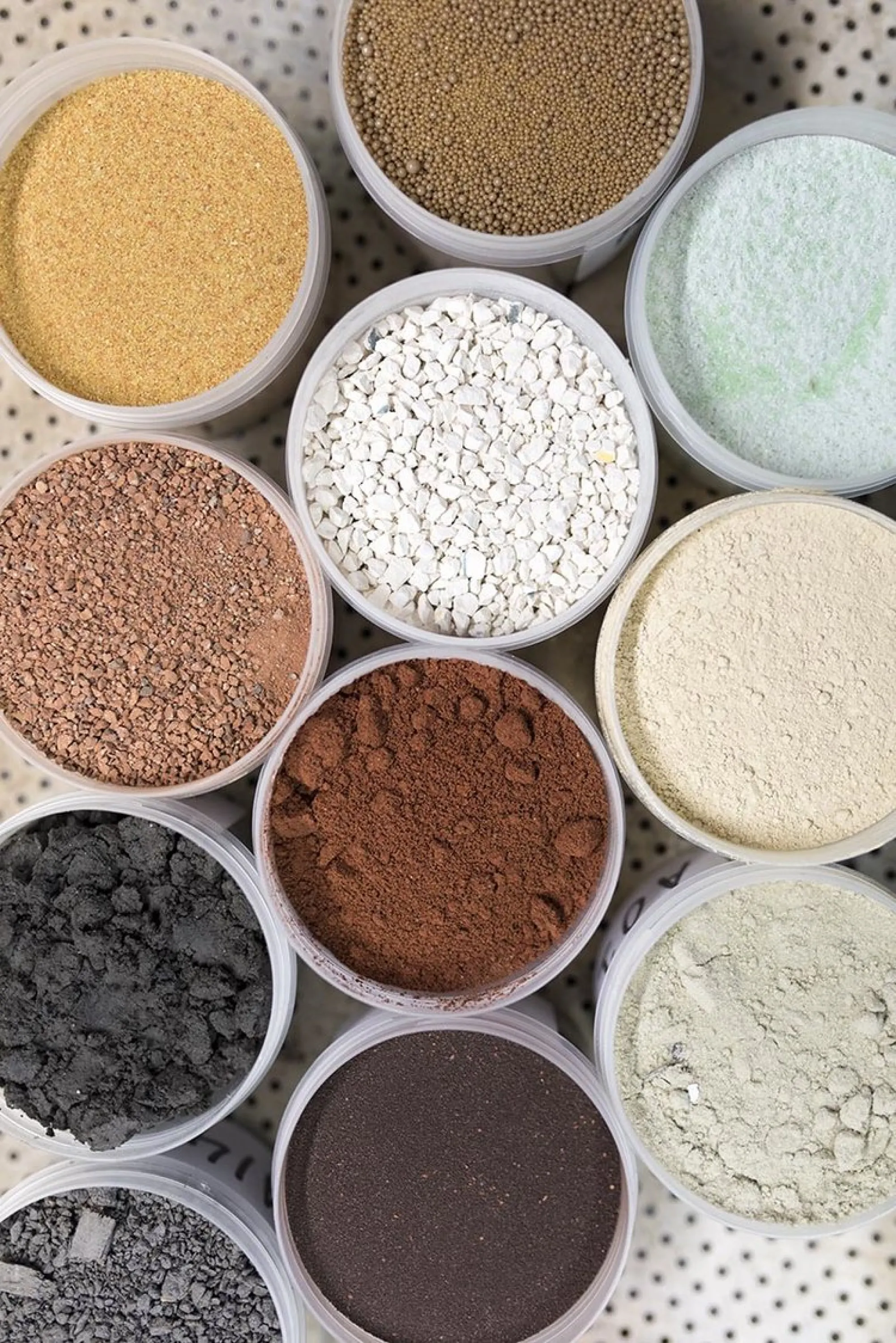 Crushed demolition debris sorted by colour, that are the raw material of waste-based bricks.