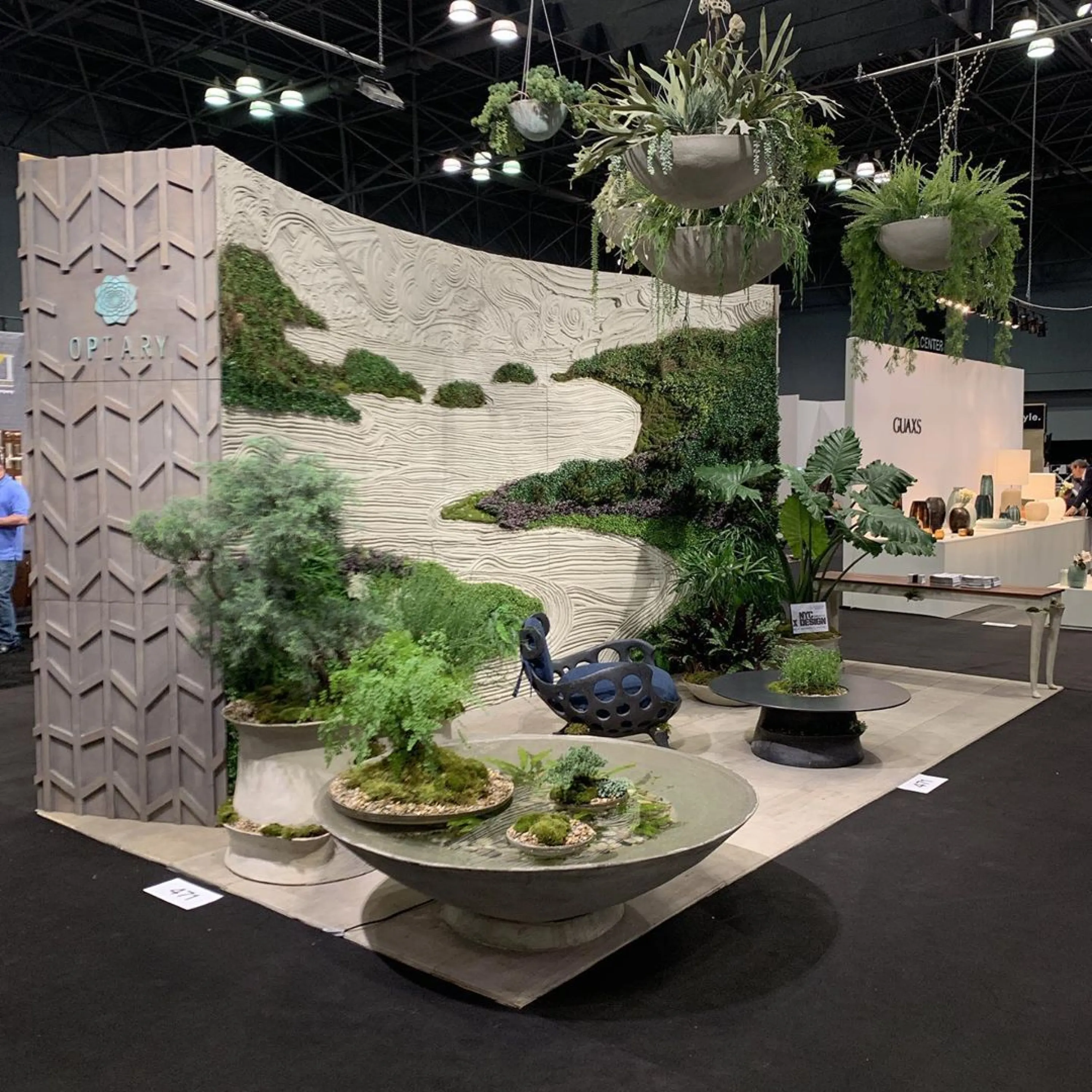 Textured surfaces and lush greenery on a booth wall.