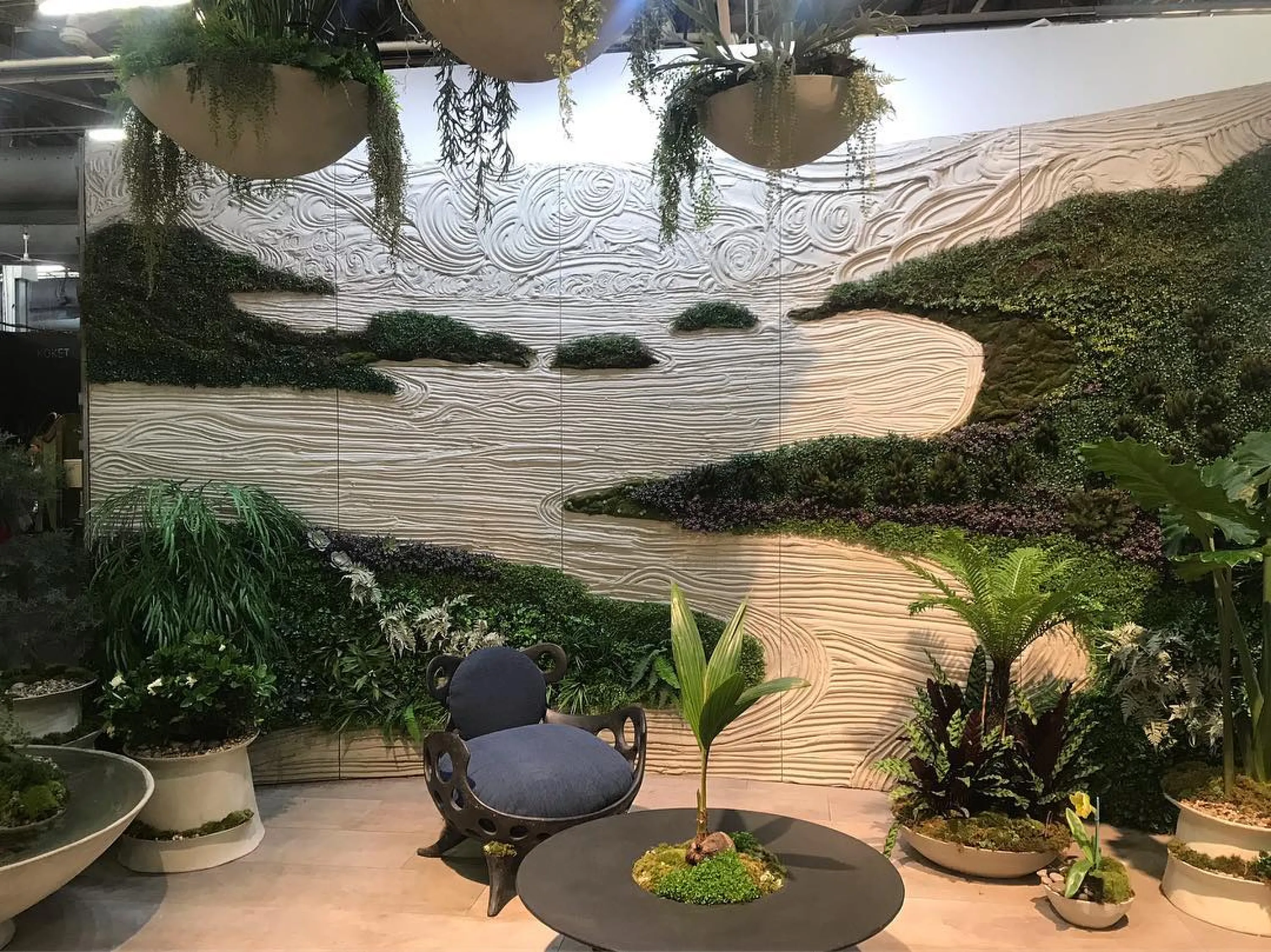 Close-up of the textured surfaces and lush greenery on the booth wall.