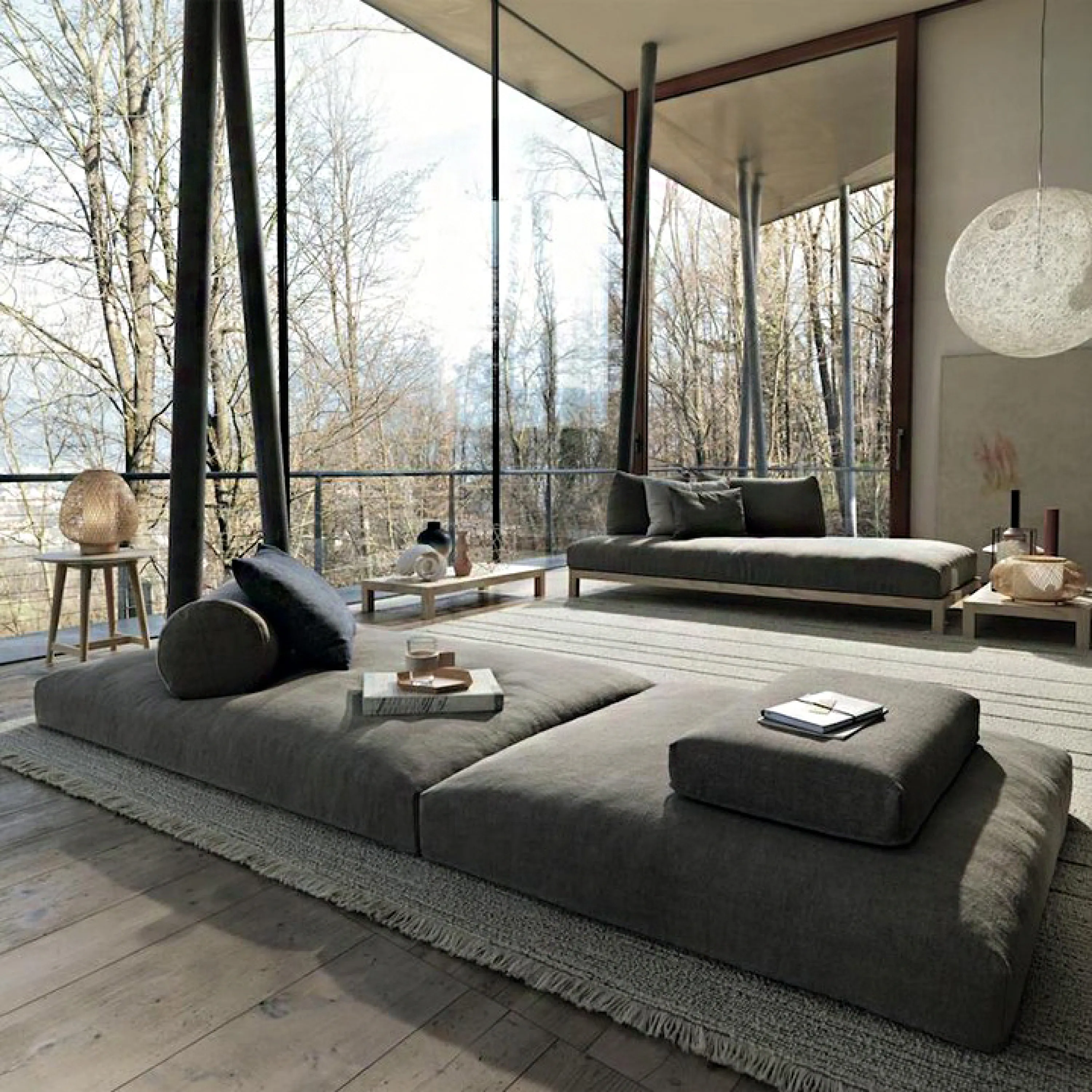 Contemporary living room with full-height windows looking into a forest.