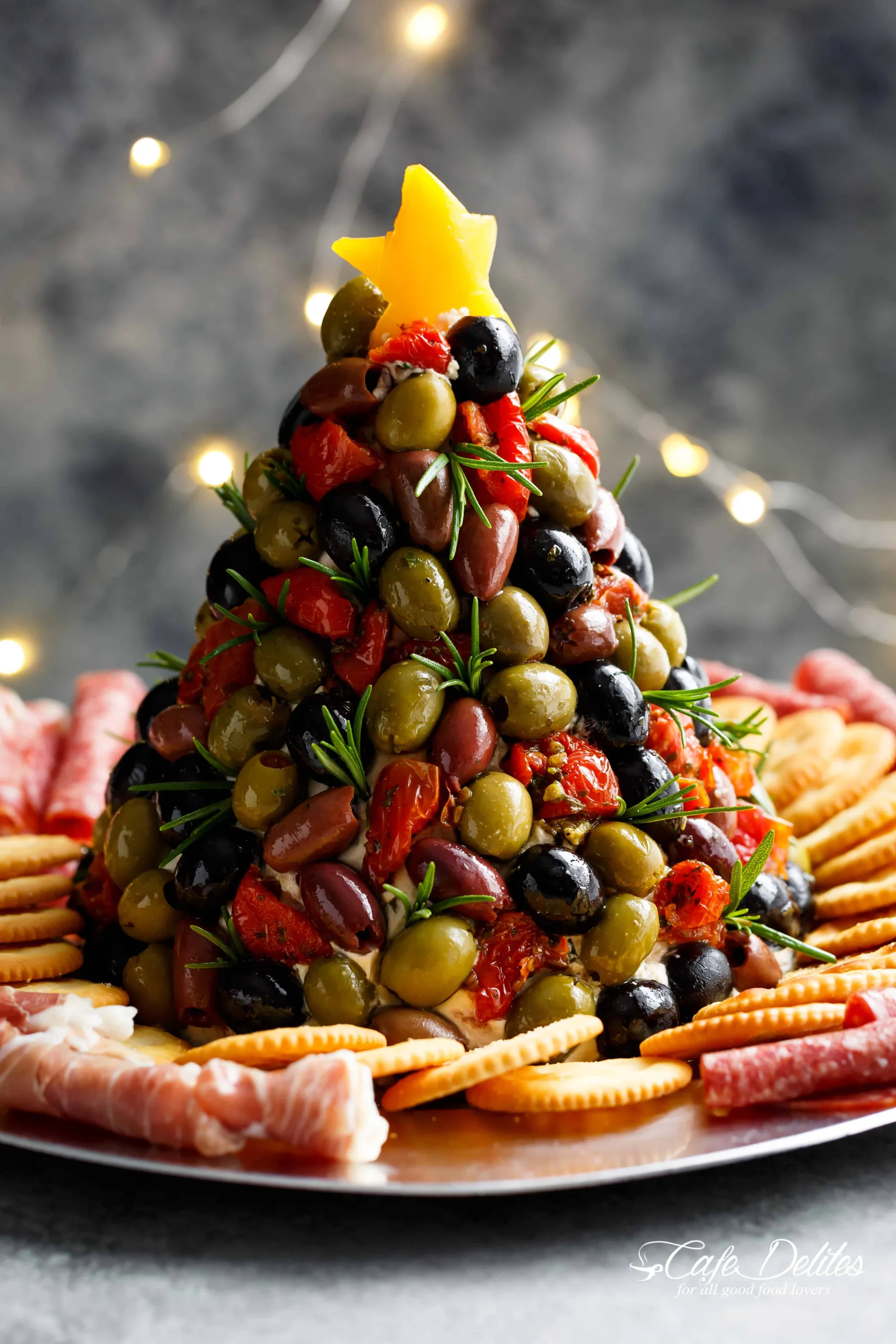 Olives and dried tomatoes arranged in the shape of a Christmas tree.