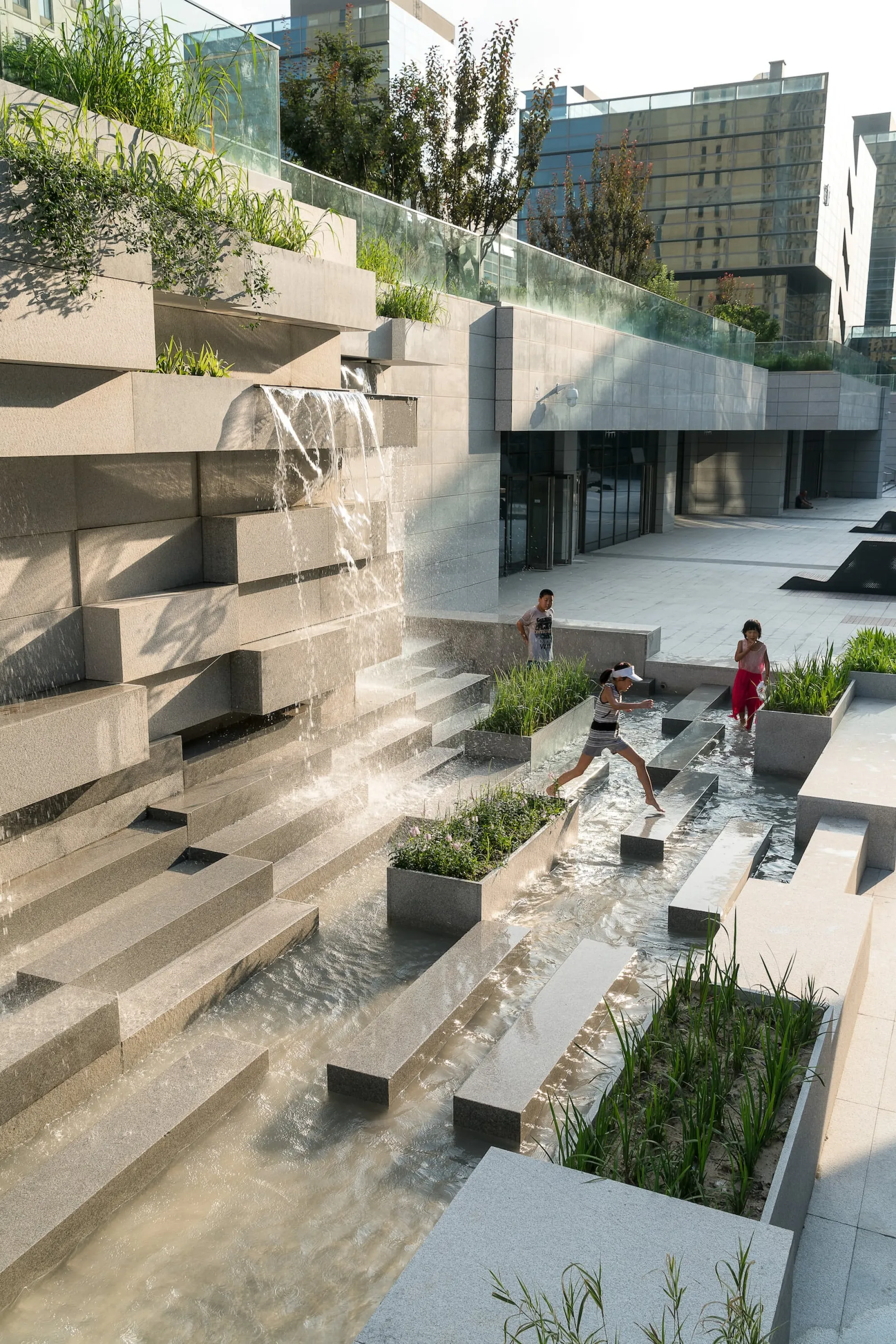 Water feature in a city invites children to play.