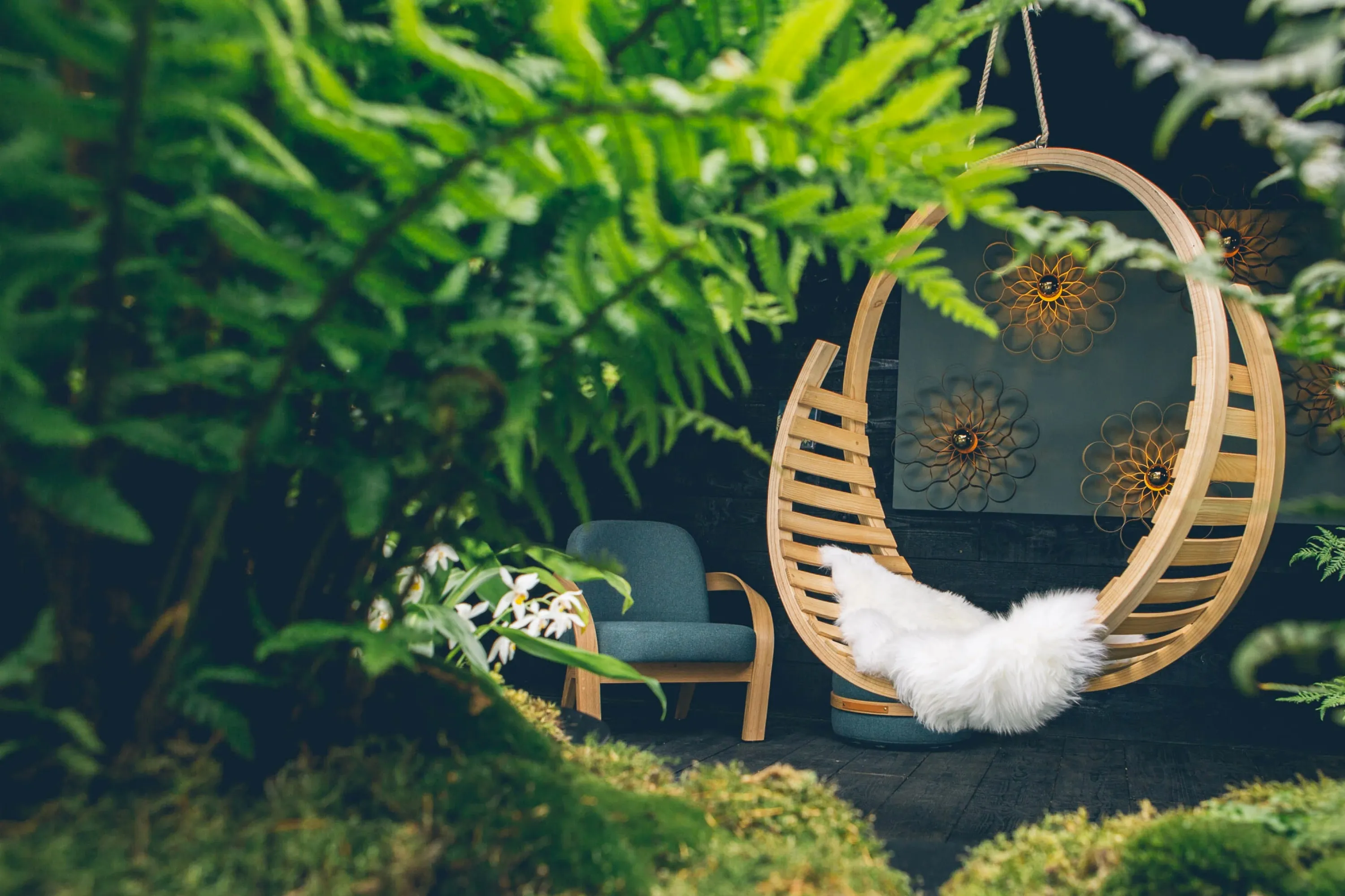 Hanging chair creating a protected corner in a booth design.