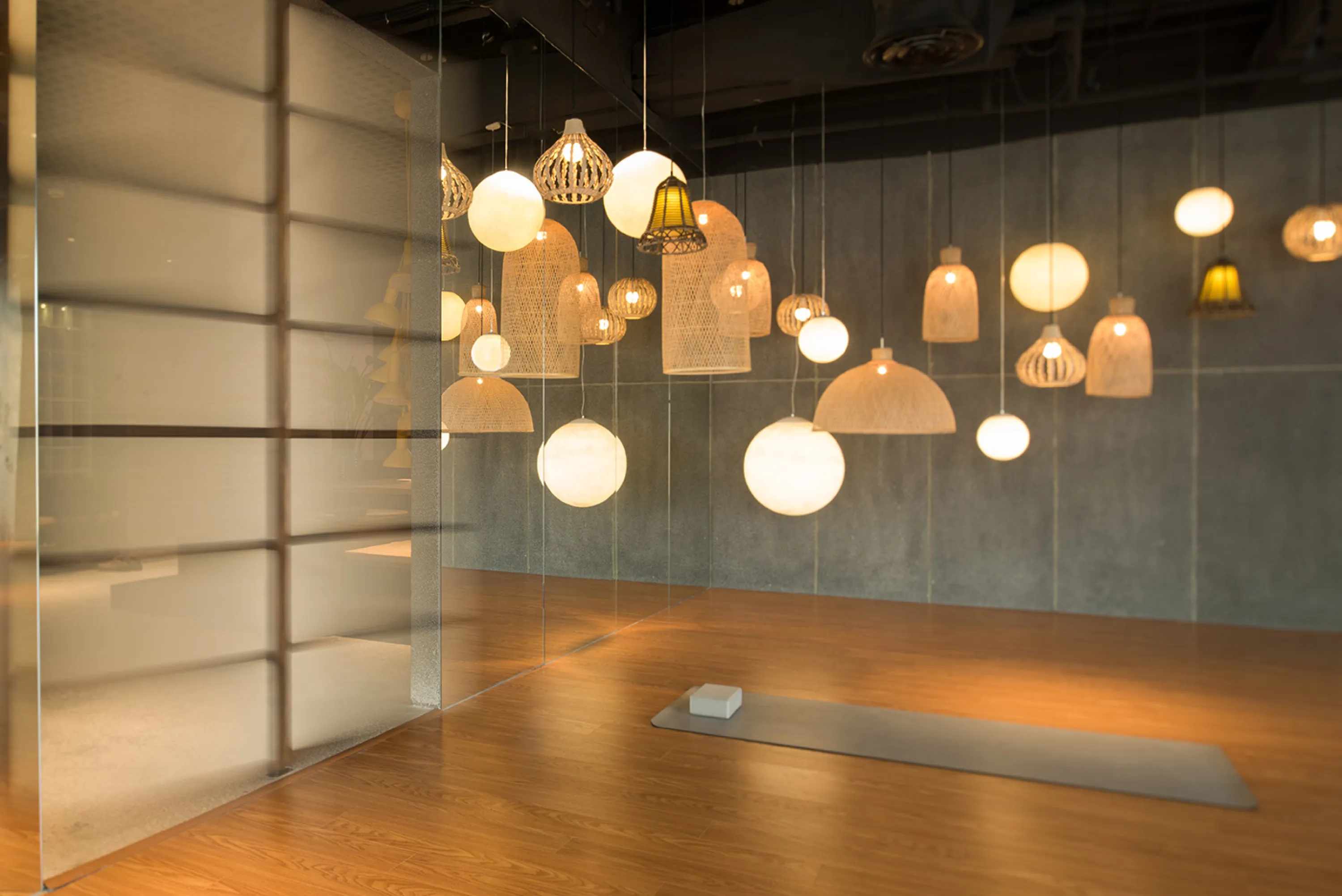 Airy meditation room with many pendant lights made of natural fibres.