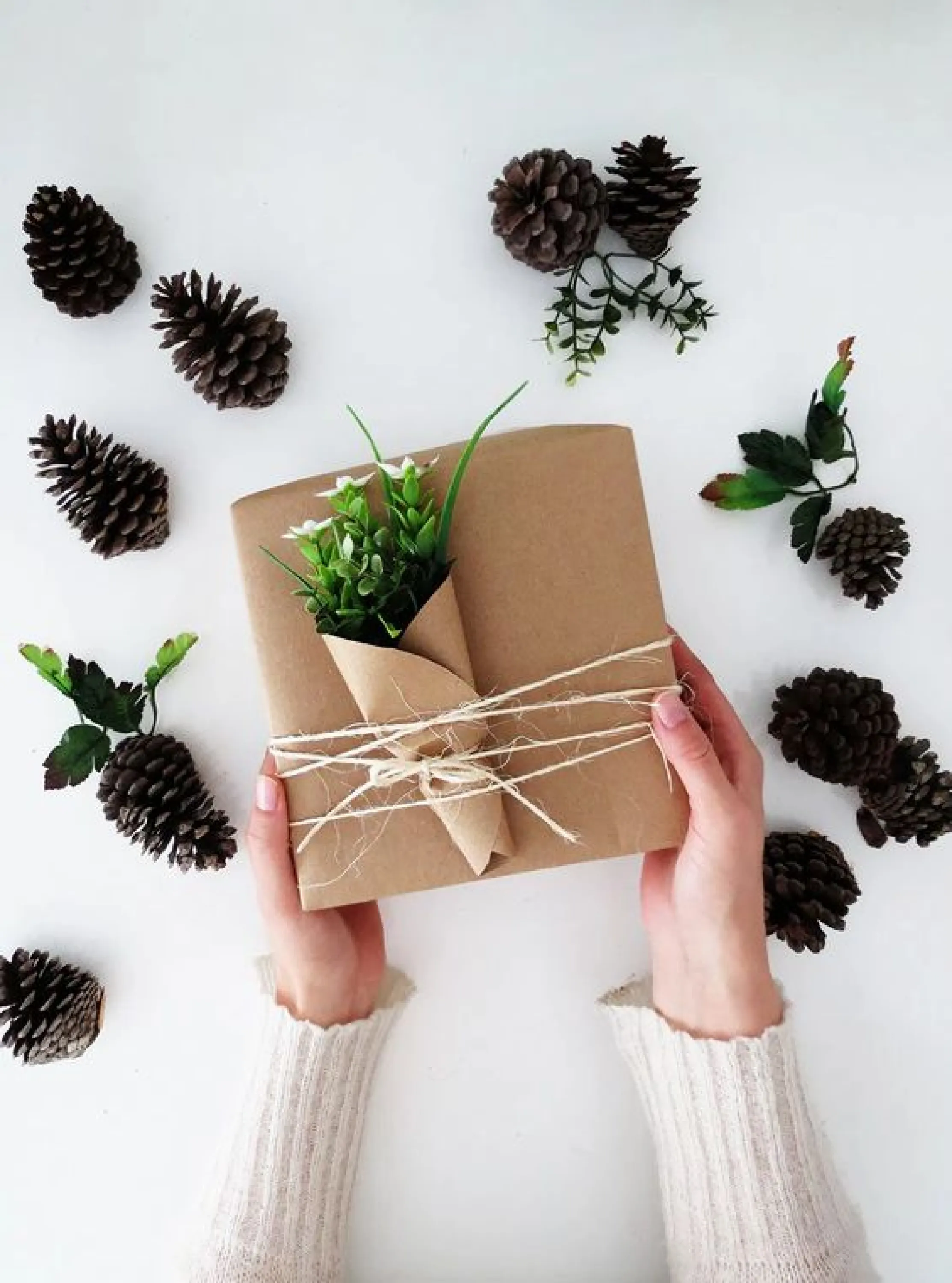 Gift wrapped in brown paper and decorated with few twigs wrapped into brown paper like a flower bundle.