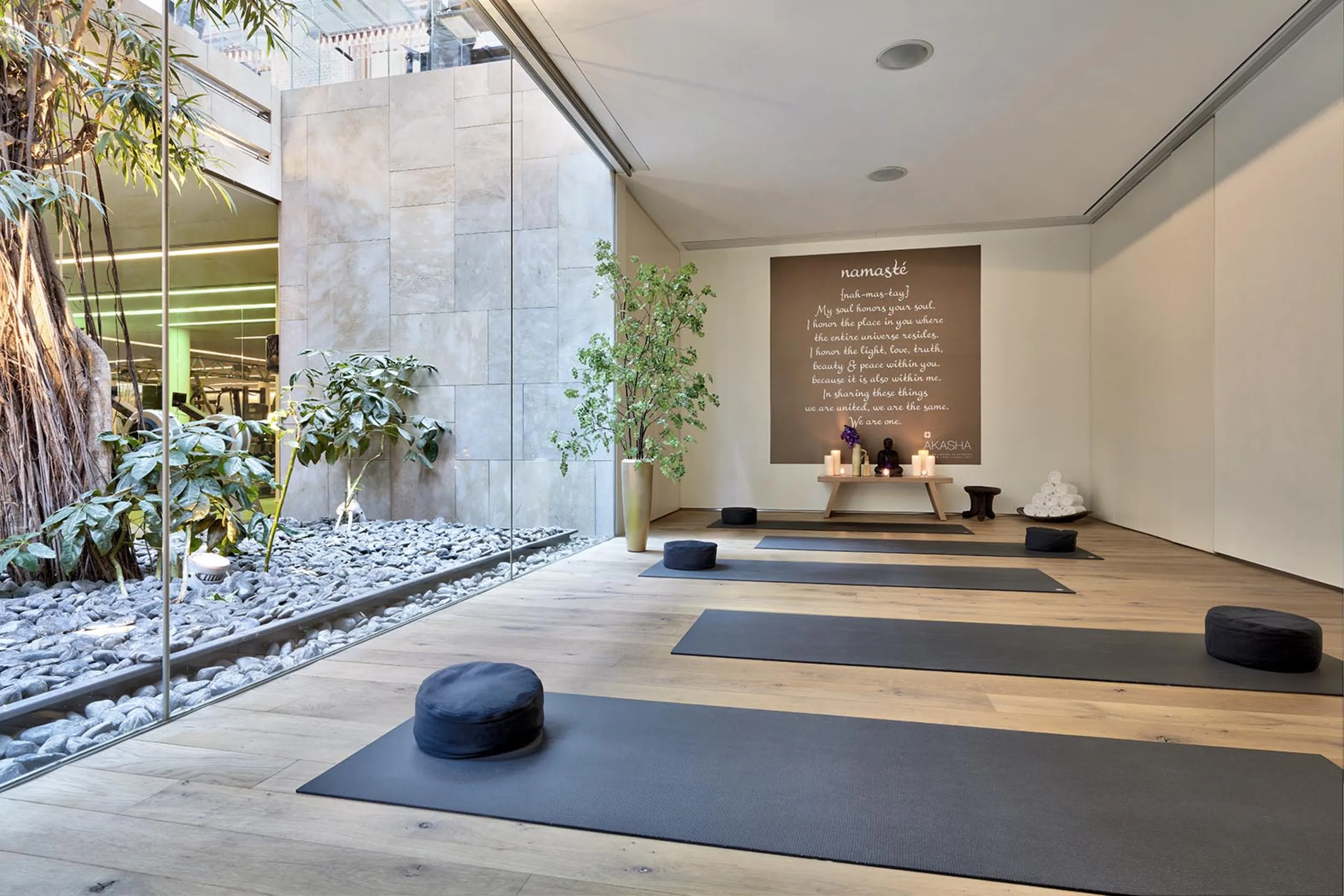 Meditation room with a full-height window looking into a patio rich in greenery.